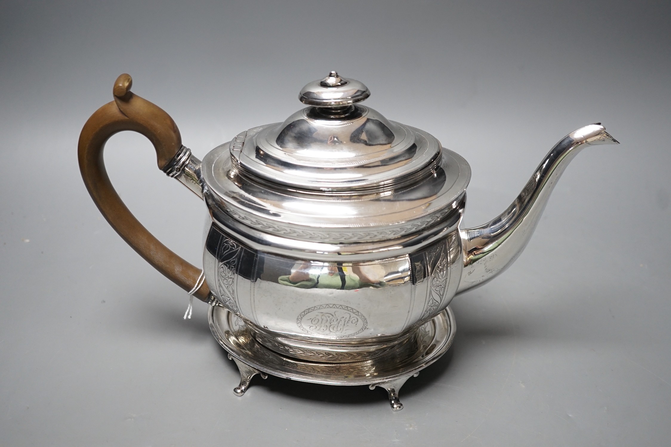 A George III engraved silver oval teapot, Alice & George Burroughs?, London, 1804 and an associated oval silver stand, James Darquits, London, 1805, gross weight 18.3oz.
